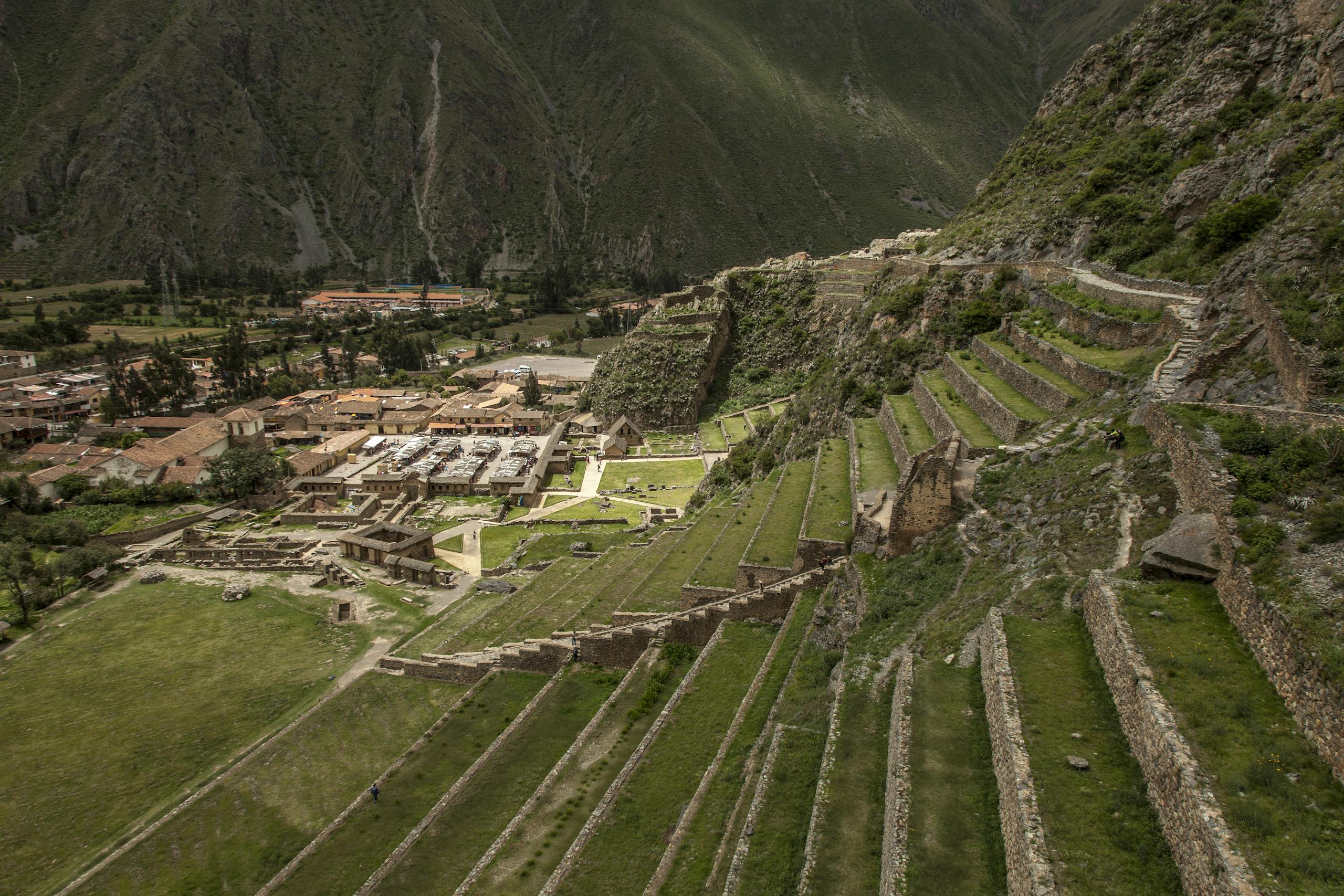 Explore the ancient Incan terraces of Ollantaytambo in Peru, captured in a stunning aerial view.